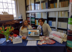 Uczniowie na stoisku przygotowanym na Festiwal zawodów, na którym znajduje się: laptop, złożone ręczniki, ulotki promujące ZSETH